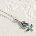 Close-up of silver necklace with abalone shell flower pendant and green gemstone leaves - Flower Necklace White Gold