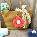 Detail view of colorful plush flower keychains hanging on a straw tote bag charm - 1 Piece / Watermelon red
