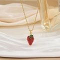 Vue macro de la chaîne dorée et du pendentif fraise en émail rouge pour femmes - Style Fraise Émail (XL0567)