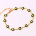 Detalle de una pulsera de oro de 18K con dijes de margaritas en esmalte verde y amarillo - Pulsera Verde