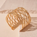 Detail of woven mesh gold cuff bracelet showing intricate texture and polished metallic finish - Gold