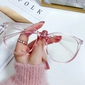 Classic oversized pink frame blue light blocking glasses shown in a lifestyle setting - Frame Only (No Lens) / Transparent Pink