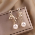 Elegant gold knot earrings with shimmering crystals and hanging white pearls - Gold