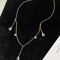 Collana a Y dorata con pendenti a goccia in zircone su sfondo di velluto nero - Oro