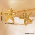 Beach style gold starfish stud earrings with realistic texture in a satin background - Gold Starfish Studs Medium