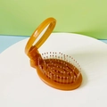 Portable orange folding hairbrush with mirror and pink tips for travel convenience - Brown