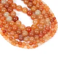 Polished natural carnelian agate round beads in vibrant orange and red shades for jewelry - Red Aventurine