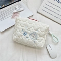 Close-up of white heart quilted makeup bag with blue cloud bunny embroidery and knot zipper - Running Rabbit