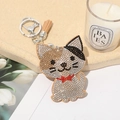 Detail showing cartoon cat keychain with rhinestones, brown tassel and silver hook - Khaki