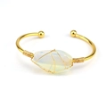 Detail of handmade gold wire-wrapped bracelet featuring a translucent raw crystal stone - Opal