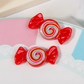 Close-up of two red resin candy charms with colorful spiral pattern for DIY crafts - Red