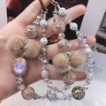 Detailed view of handmade beaded phone chain with rose gold rhinestones and brown pom-poms - Rose Gold Brown