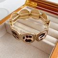 Dettaglio del bracciale elastico leopardato con maglie in metallo dorato sbalzato - Pannello con Motivo Leopardato / Marrone oro