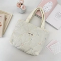Close-up of beige quilted tote bag with colorful heart embroidery and brand logo - Multicolor Gourd Heart