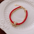 Detalle de pulsera de cuero rojo de doble capa con dije en X de circonita dorada y corazón - Pulsera-Rojo