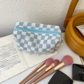 Blue and white checkered knitted cosmetic bag with a light blue zipper on an open book - Blue / Blue and White Checkerboard