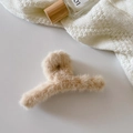 Detail of plush beige shark hair claw clip on white knit sweater background - Crossed / Light Coffee