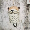 Detailed close-up of a hand-painted resin otter wind chime with metal bell and ceramic leaf - Sloth