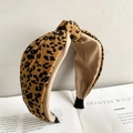 Detail of yellow leopard print knotted headband on a vintage book with stylish textures - Leopard Coffee