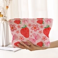 Pink corduroy makeup bag with strawberry and floral bow print shown in hand - Pink Strawberry Flower Bow (MT0226026)