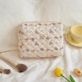 Détail de la trousse de maquillage matelassée crème avec motifs éléphant et texture - Éléphant à Nœud Papillon