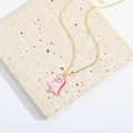 Minimalist golden chain necklace featuring a cute pink dinosaur pendant on marble surface - Pink Dinosaur XL3330-1
