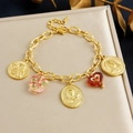 Bracciale vintage placcato oro con ciondoli a moneta, rilievo a croce e charms in vetro - Bracciale (B1947)