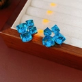 Macro view of blue cube crystal flower earrings on a vintage wooden jewelry box - Silver Pin / Crystal Glass / Blue Geometric Cube Style