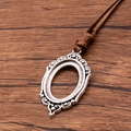 Vintage silver oval pendant base with brown PU braided cord on wood background - Carved Beaded Oval Style