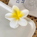 Close-up of frangipani hair claw clip with matte white petals and yellow center - Yellow & White Flowers