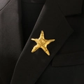 Primer plano de un broche de estrella de mar dorada con textura martillada en traje - Estilo Estrella de Mar Espiral (03 Oro Titanio 6219)