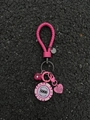 Détail du porte-clés tressé rose avec jeton de poker et pendentif coeur sur le sol - Style Jeton en Corde de Cuir Rose
