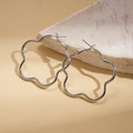 Dettaglio di orecchini a cerchio a fiore in argento appoggiati su marmo - Argento (Perno per orecchini in argento sterling 925)