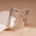 Detail of silver textured open bangle with hollow cutout on stone display - Silver