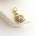 Dettaglio macro del ciondolo a coccinella dorata con gemme viola e rosse vivaci - Coccinella