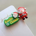 Dettaglio molletta natalizia con Babbo Natale e elemento decorativo verde su carta - Stile 27 Fermaglio per Capelli Natalizio