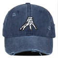 Close-up of distressed navy denim baseball cap with white hand gesture embroidery detail - One Size / Navy Blue