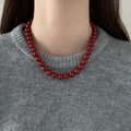 Close-up of deep red glass beads necklace on model neck with grey sweater - 9mm / Red