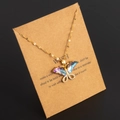 Goldene Schmetterlingshalskette mit schillernden Flügeln und Kristallen auf Kraftpapier - Stil D Gold