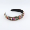 Detail view of colorful baroque rhinestones and crystals on a black fashion headband - Colorful
