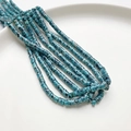 Filo di perline distanziatrici cilindriche blu in pietra sintetica 4x2mm su piatto bianco - Pietra a Punti Verdi