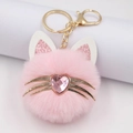 Pink plush cat head keychain with gold hardware and a pink heart jewel detail - Pointed Ears