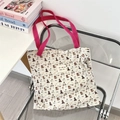Detail of cute puppy print canvas tote with pink handle and woven logo patch - Skating Dog