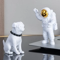 Astronaut figure with gold visor and pug statue sitting on a minimalist desk - Small Plated Gold Model A + White Dog