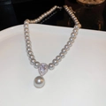 Primer plano de collar de perlas de doble capa con un colgante de gota brillante - Gris