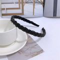 Detail view of a black beaded braided headband styled next to a white cup and saucer - Black