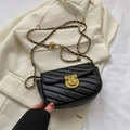 Sacoche noire en cuir matelassé avec chaîne dorée posée sur un blazer ivoire - Noir