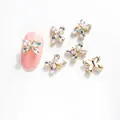 Detalle de dijes para uñas mariposa cristal K9 11x8mm con base dorada y brillantes 3D - Estilo Mariposa (LF7001) / 11x8mm / Blanco Iridiscente (Base Dorada)