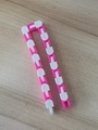 Pink and white Wacky Tracks fidget toy with 24 interlocking links on a wooden surface - White Pink