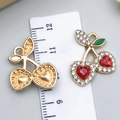 Macro view of cherry pendants with red heart stones and back texture against a ruler - Red Rhinestone Heart Cherry (23421)